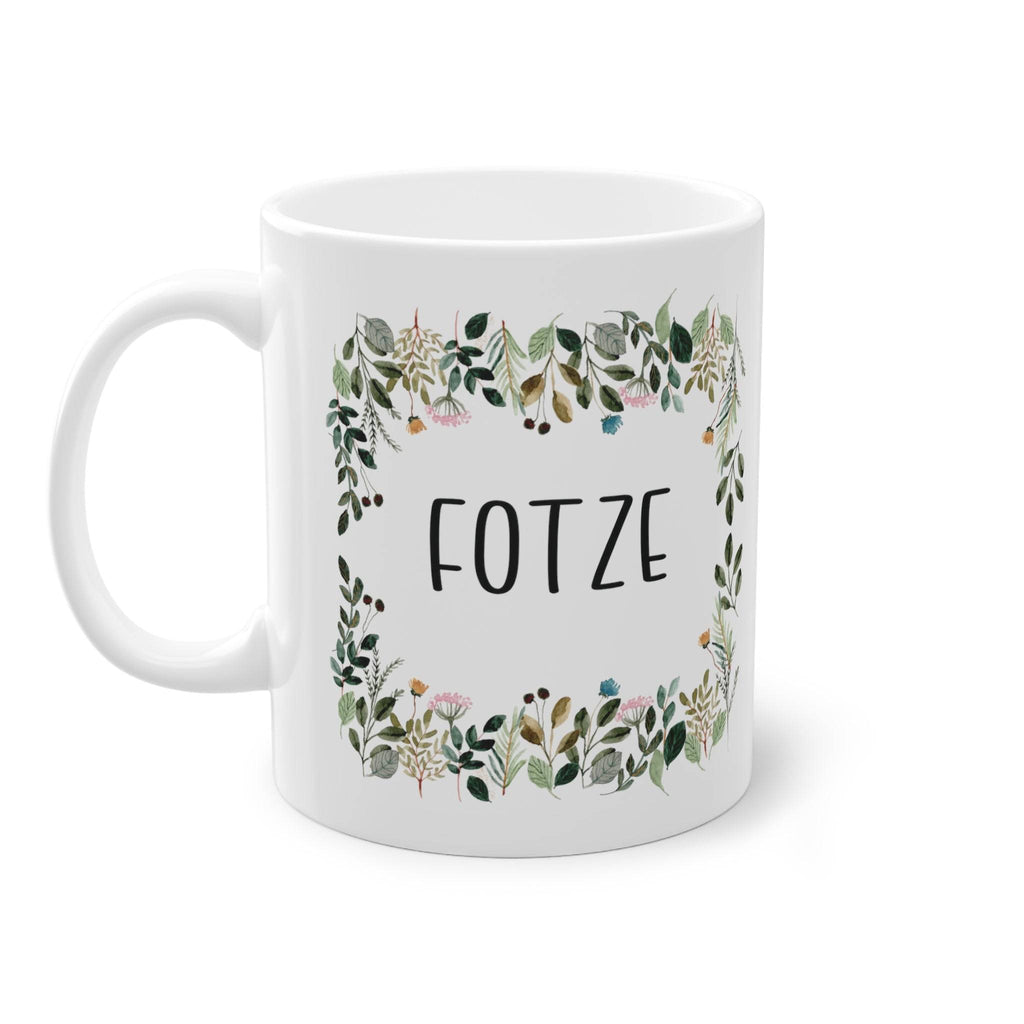 a white coffee mug with a floral frame on it