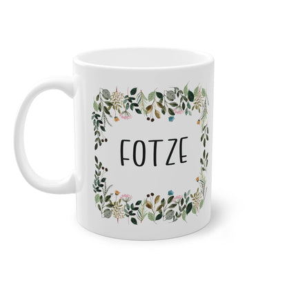 a white coffee mug with a floral frame on it