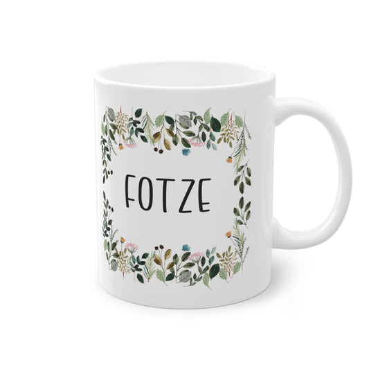 a white coffee mug with a floral frame on it