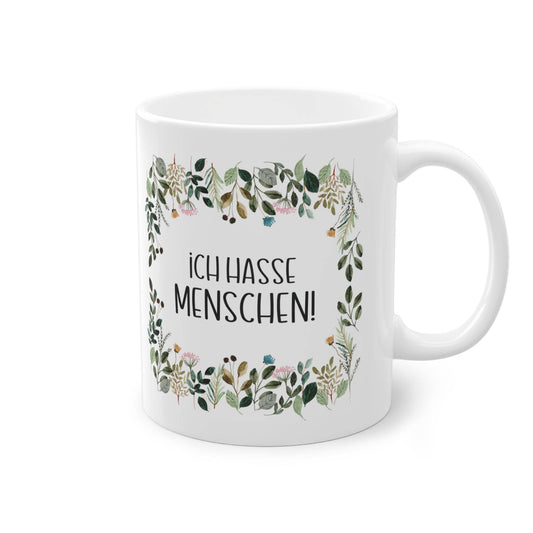 a white coffee mug with a floral frame on it